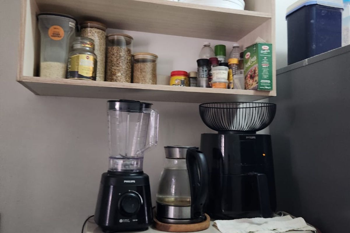A kitchen storage area featuring open shelving and a built-in microwave unit.