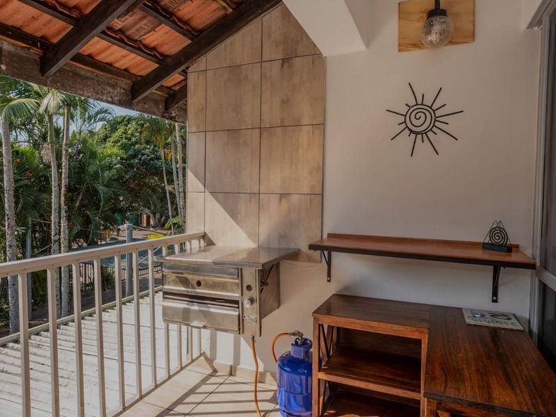 Covered balcony featuring a built-in gas braai, tiled splashback, and metal railings, offering a functional outdoor entertainment space.