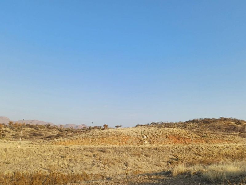 A scenic view of the natural hilly landscape and open terrain surrounding the vacant residential property.