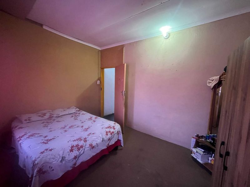 A simple bedroom featuring plain walls and a standard internal door, requiring cosmetic updates to improve the overall aesthetic and finish.