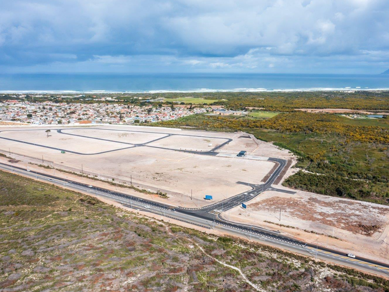 Aerial view of a large, cleared commercial vacant land development featuring established internal road infrastructure and proximity to coastal residential areas.