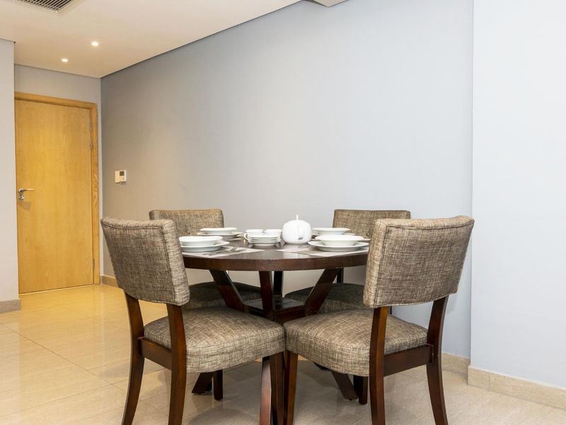 A well-maintained dining area featuring neutral wall tones, tiled flooring, and recessed ceiling lighting, providing a clean and functional space.