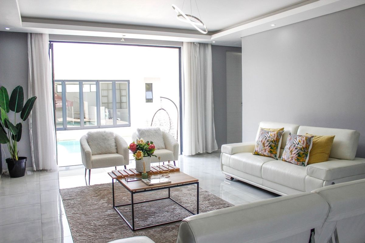 Modern open-plan living area featuring large sliding glass doors that provide seamless access to the outdoor pool area and abundant natural light.