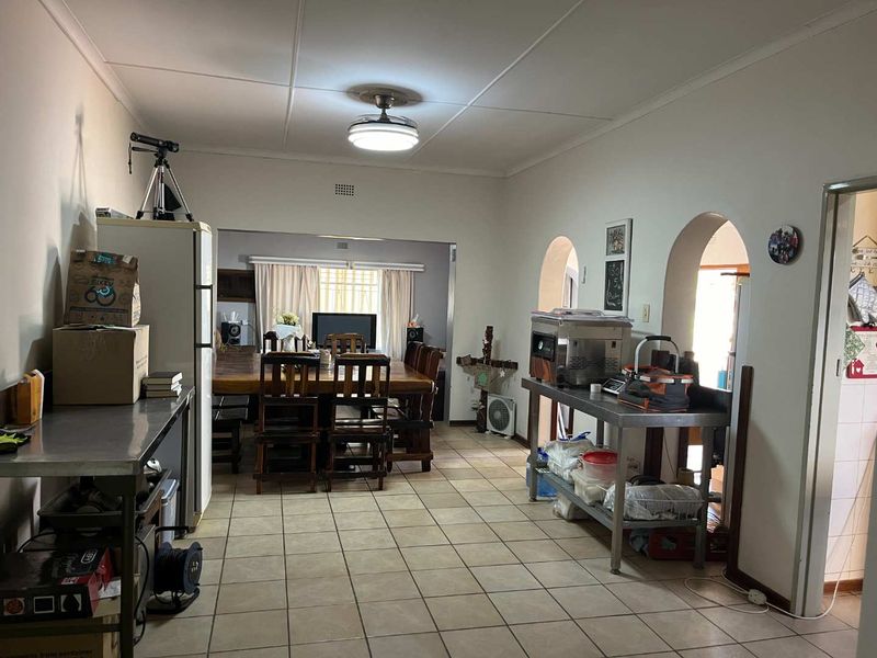 Open plan living and dining area featuring tiled flooring and distinctive arched architectural details connecting the spaces.