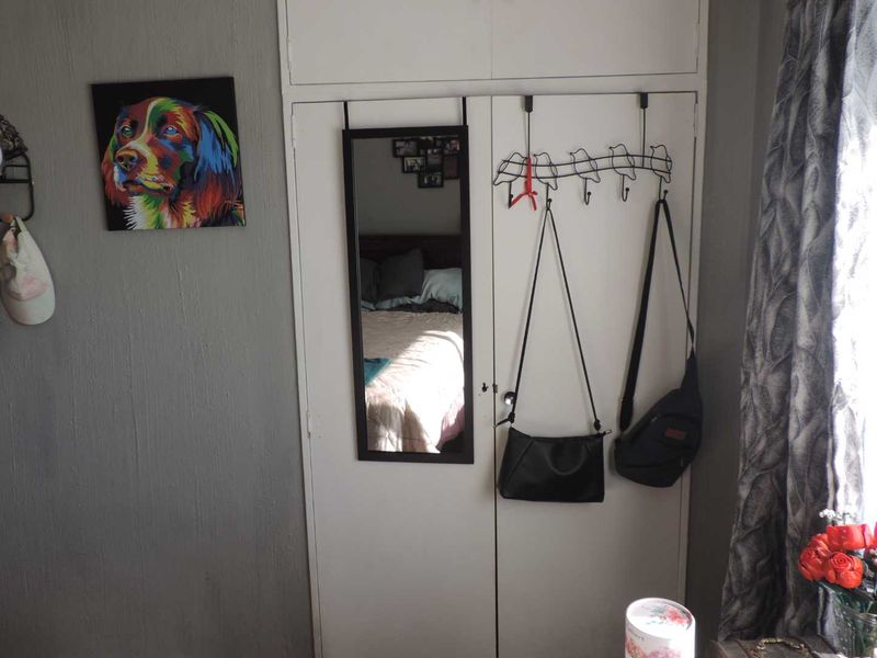 A bedroom featuring a white built-in wardrobe with double doors.