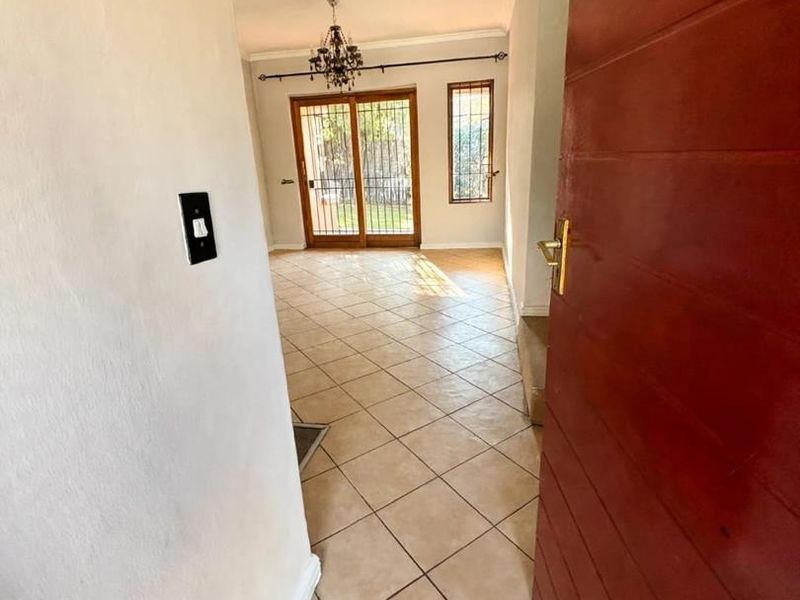An inviting entrance hall featuring tiled flooring and a sliding glass door that provides access to the outdoor area.