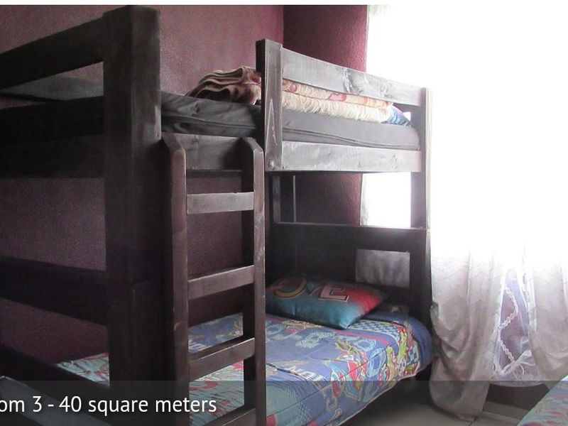 A bedroom featuring dark-painted walls and natural light from a window.