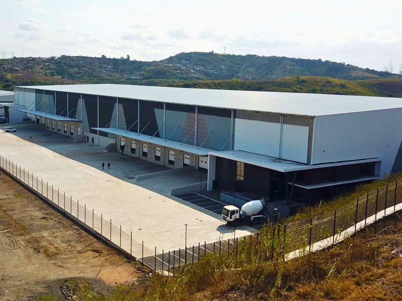 Aerial view of a large industrial warehouse facility featuring multiple loading docks, extensive concrete yard space, and secure perimeter fencing.