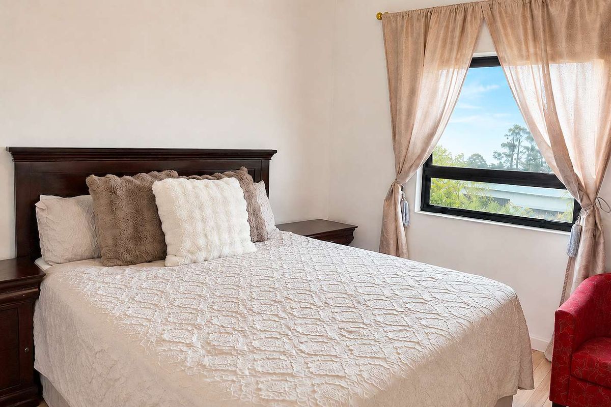 A bedroom featuring a window with natural light, providing a comfortable and functional sleeping space.