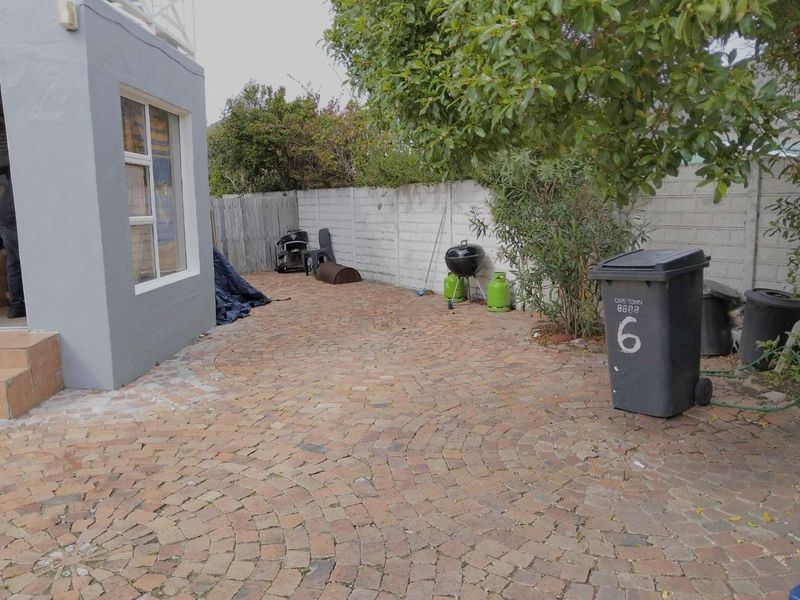 A rear courtyard area featuring brick paving and a concrete boundary wall, providing a functional outdoor space.