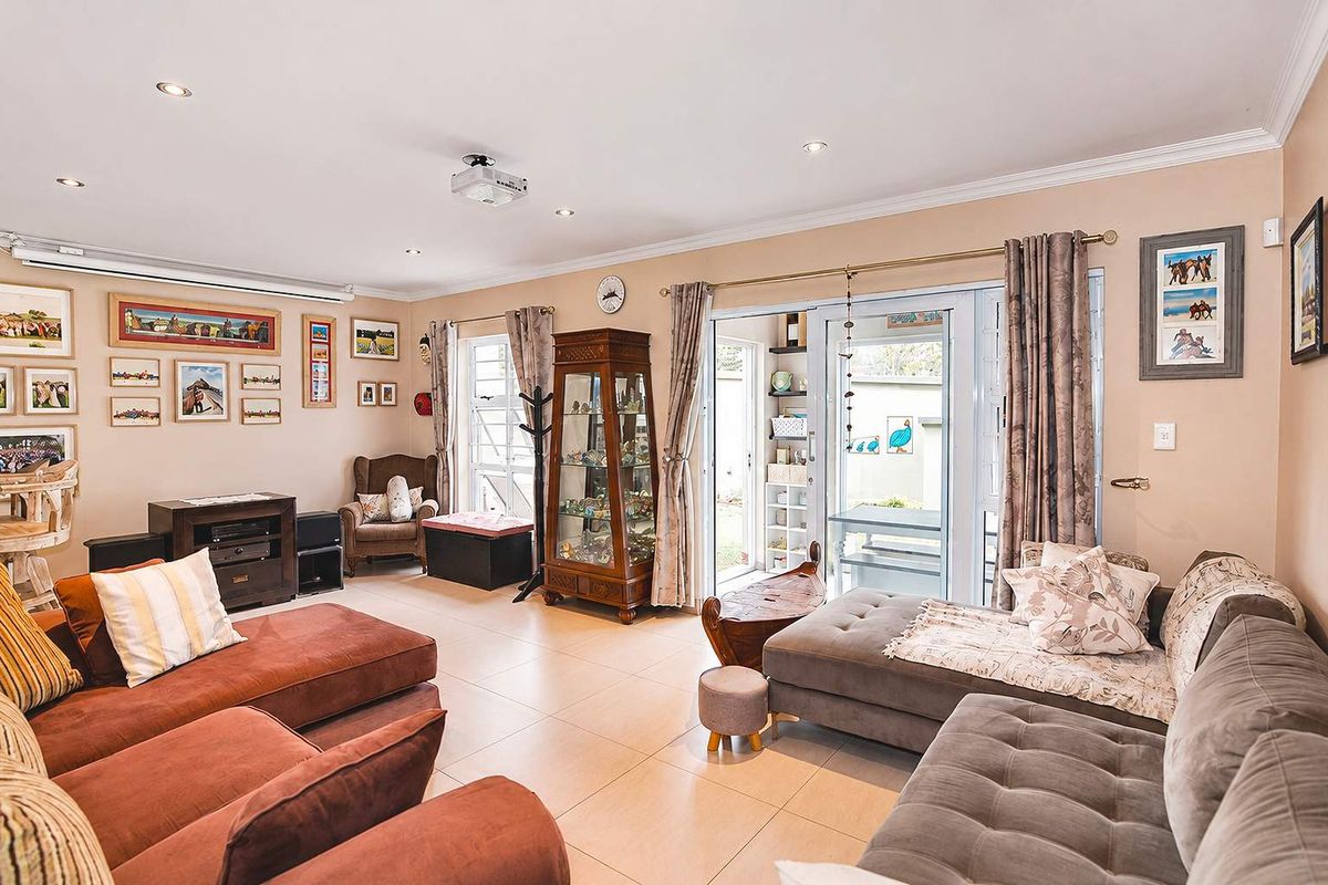 Spacious living room featuring tiled flooring, recessed downlighting, and sliding glass doors providing access to the outdoor area.