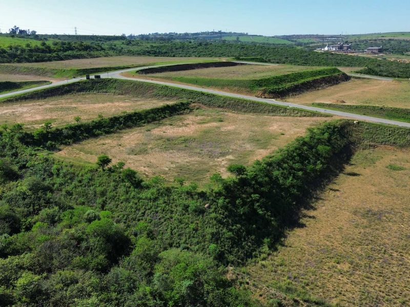 Aerial view of a large, terraced industrial land parcel featuring established access roads and cleared development platforms.