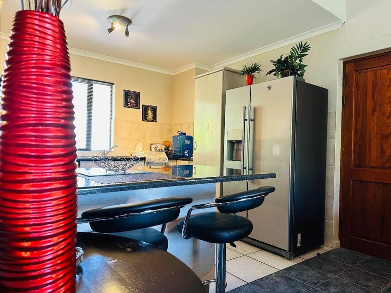 A functional kitchen featuring granite countertops, a breakfast bar, and built-in cabinetry, providing a practical space for cooking and casual dining.