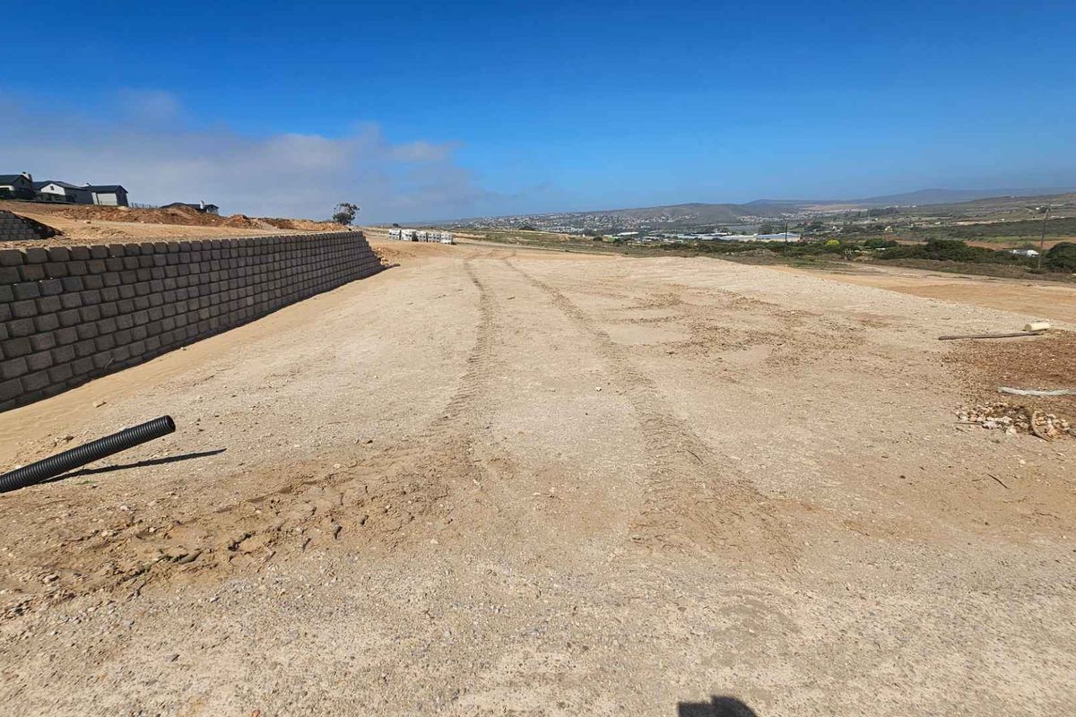 A vacant plot of land featuring a retaining wall and expansive views, ready for residential development.