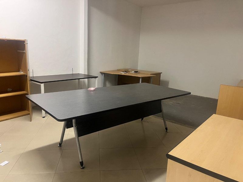 A functional office space featuring tiled flooring and neutral wall finishes, suitable for a professional work environment.