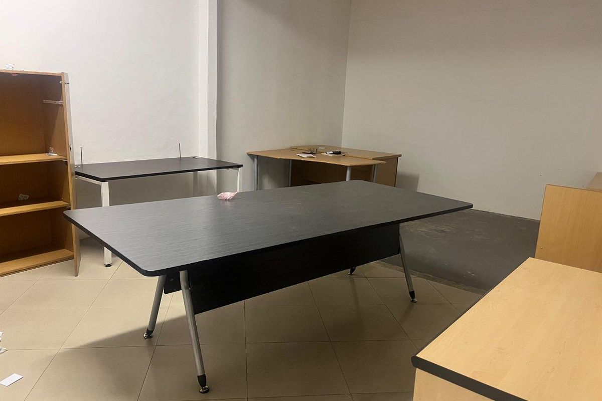 A functional office space featuring tiled flooring and neutral wall finishes, suitable for a professional work environment.