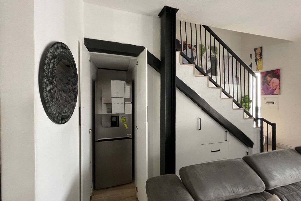 Living area featuring a staircase with integrated under-stair storage cabinetry and a prominent structural steel column.