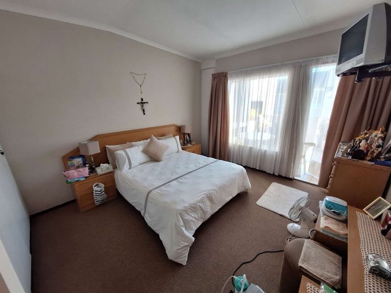 A carpeted bedroom featuring a sliding glass door that provides access to an outdoor area, allowing for natural light.