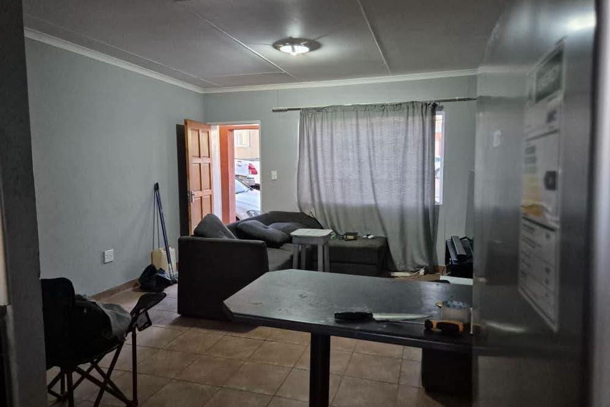 Open plan living area featuring tiled flooring, a breakfast bar, and direct access to the exterior.