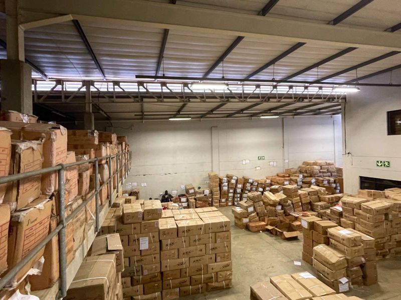 Spacious industrial warehouse unit featuring high ceilings with exposed steel trusses, a mezzanine level, and concrete flooring, suitable for storage or light manufacturing.