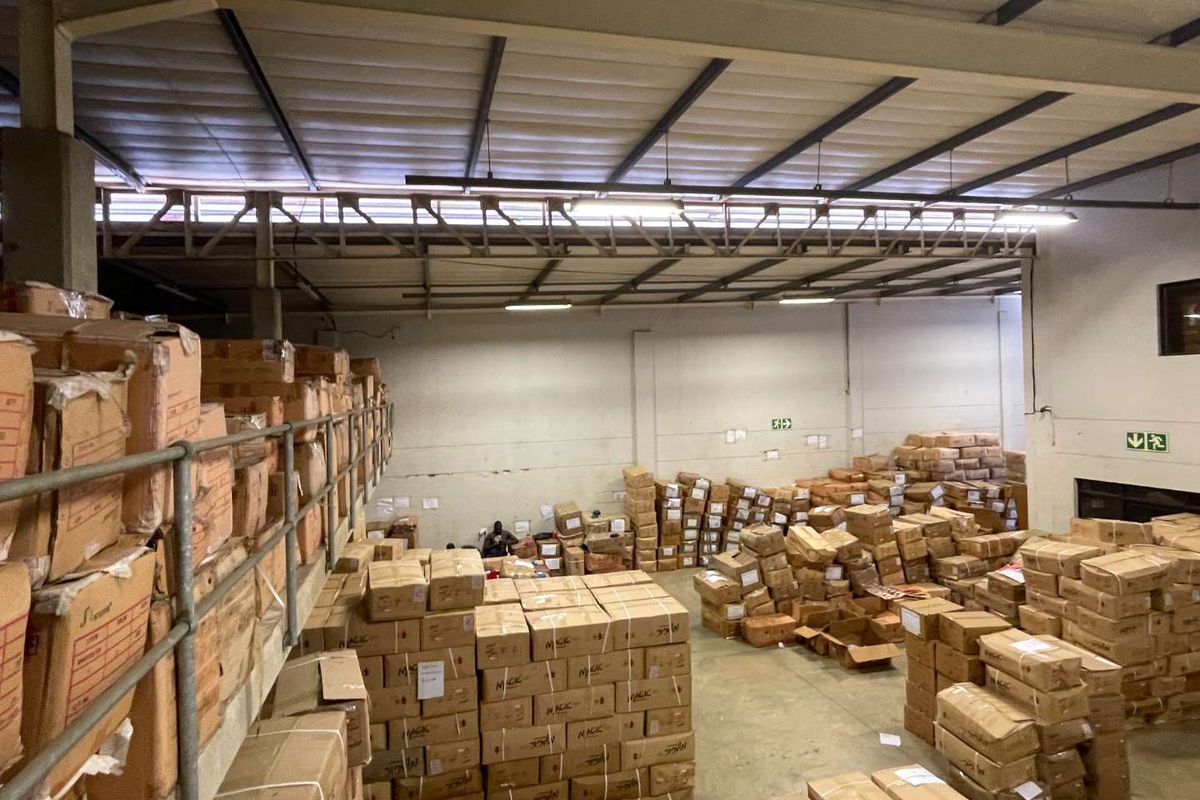 Spacious industrial warehouse unit featuring high ceilings with exposed steel trusses, a mezzanine level, and concrete flooring, suitable for storage or light manufacturing.