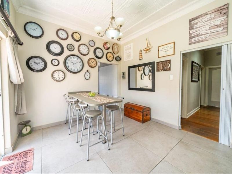 Dining area featuring tiled flooring, an ornate ceiling with a chandelier, and a sliding glass door providing access to the exterior.