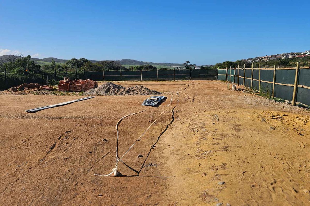 A vacant, cleared plot of land enclosed by perimeter fencing, ready for development or landscaping.