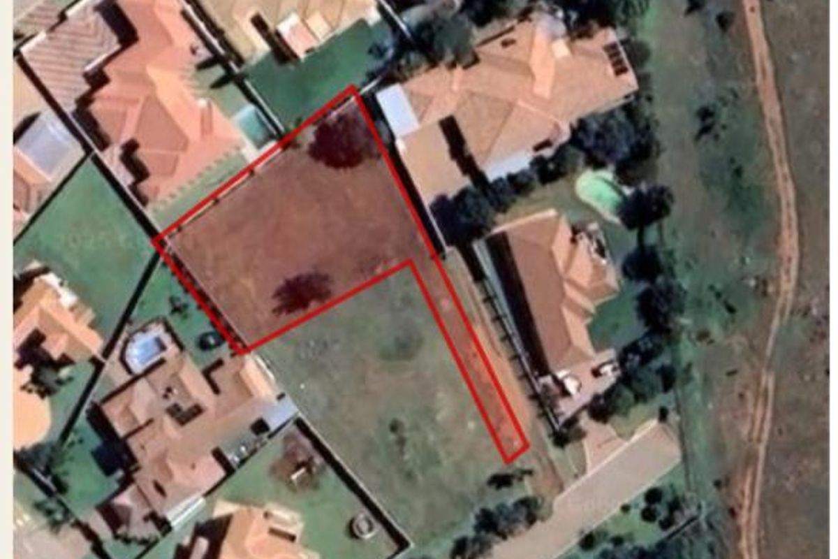 Aerial view of a vacant residential plot with a defined boundary, situated within an established suburban neighborhood.