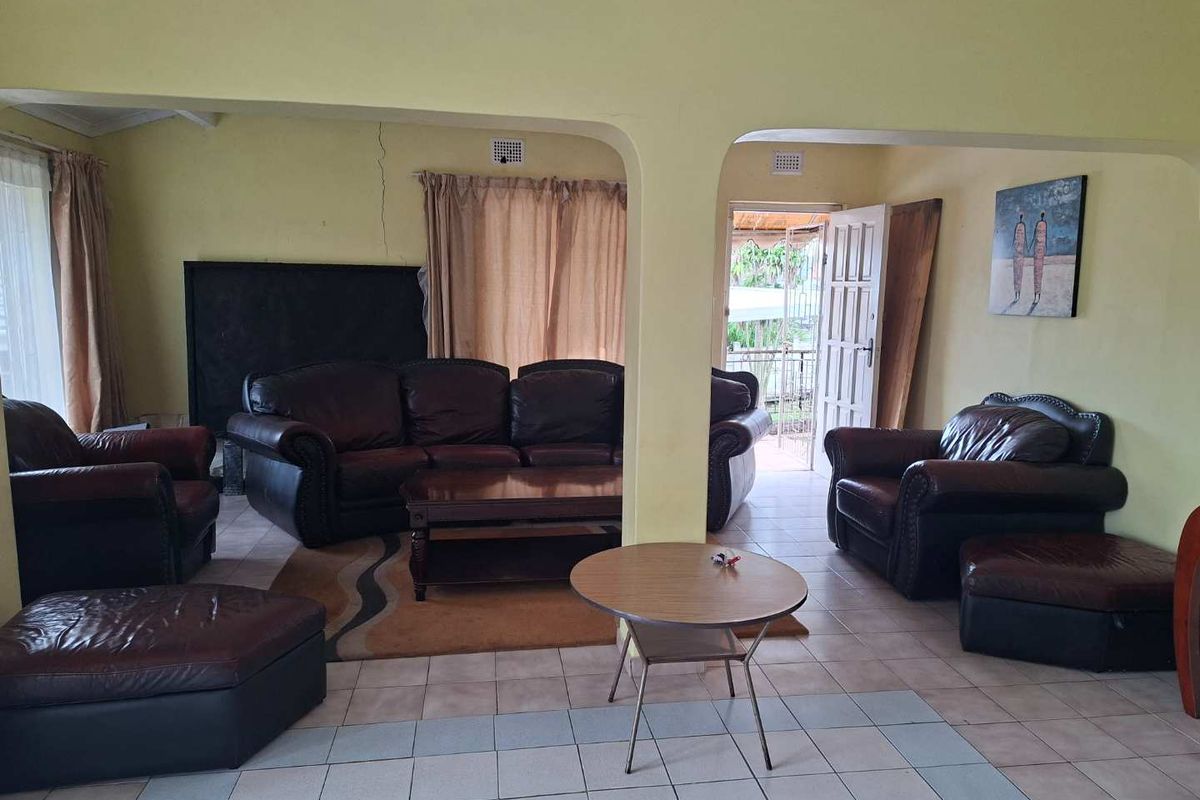 Spacious living area featuring tiled flooring and arched wall openings, with a visible structural crack requiring attention.