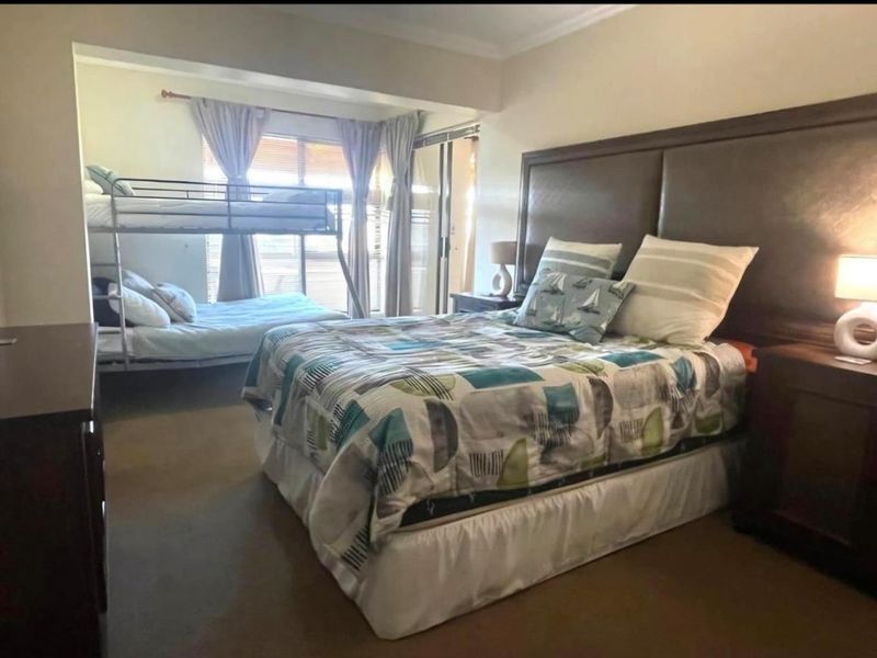 Spacious bedroom featuring carpeted flooring, cove cornicing, and a sliding glass door leading to an outdoor area.