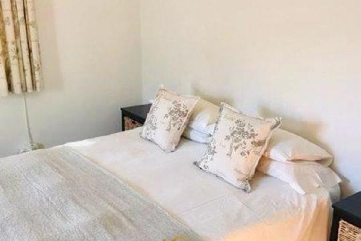 A simple bedroom featuring neutral walls and a functional layout, suitable for a comfortable living space.