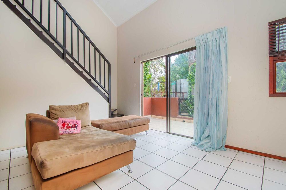 Lounge with sliders out to the balcony with braai area