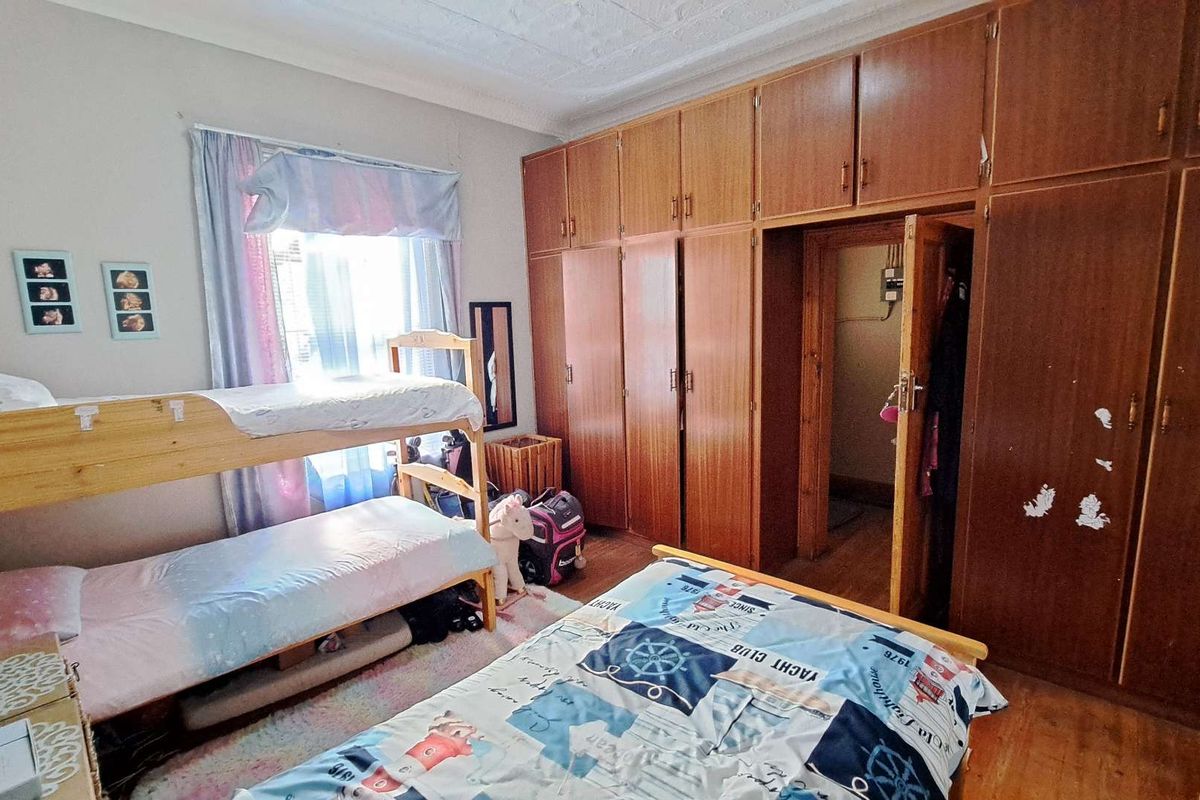 Bedroom featuring extensive built-in wooden cabinetry providing ample storage space and a doorway leading to an adjacent area.