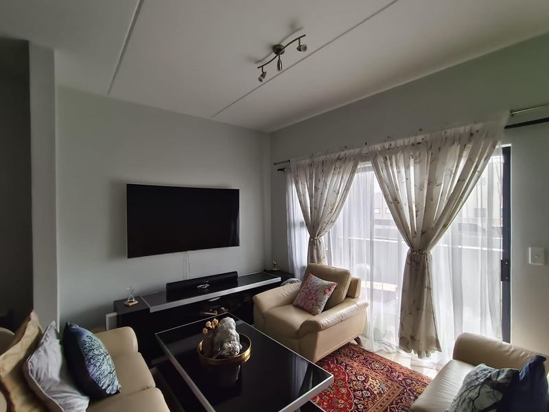 A comfortable living room featuring a sliding glass door that provides natural light and access to the balcony.