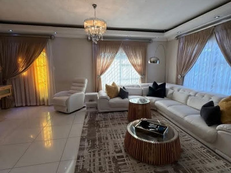 Spacious living room featuring large format floor tiles, recessed ceiling lighting, and a built-in ducted air conditioning unit.