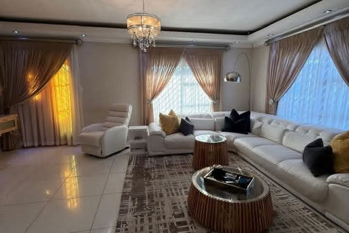 Spacious living room featuring large format floor tiles, recessed ceiling lighting, and a built-in ducted air conditioning unit.