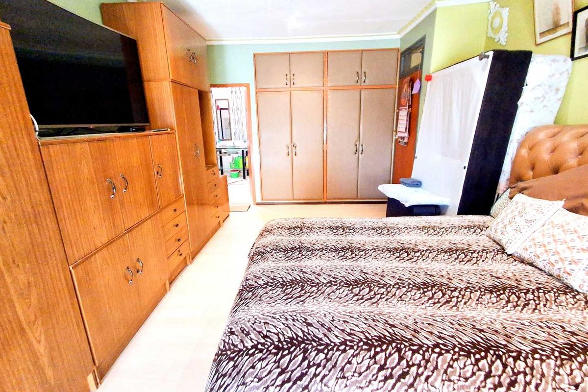 A bedroom featuring extensive built-in wooden cabinetry and wardrobes, providing ample storage space.