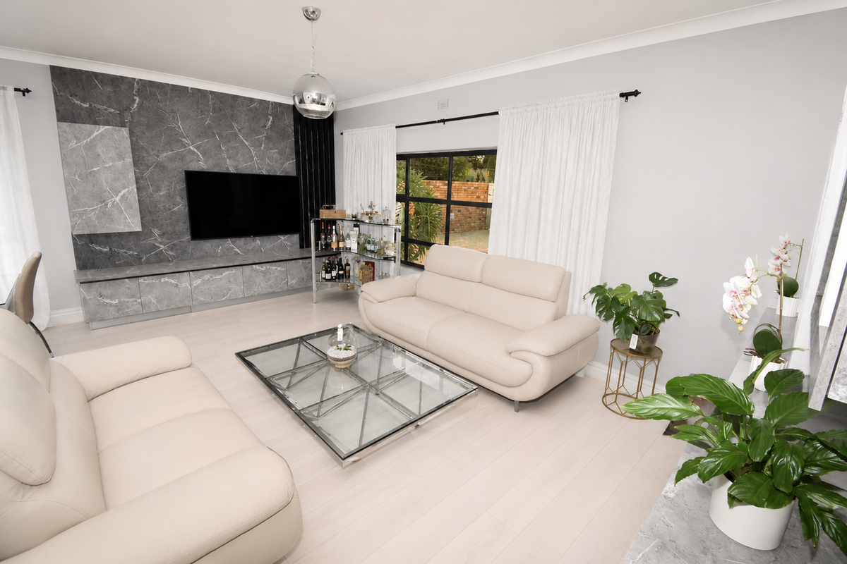 Modern living room featuring a striking marble-look feature wall with integrated cabinetry and large windows, creating a bright and contemporary living space.