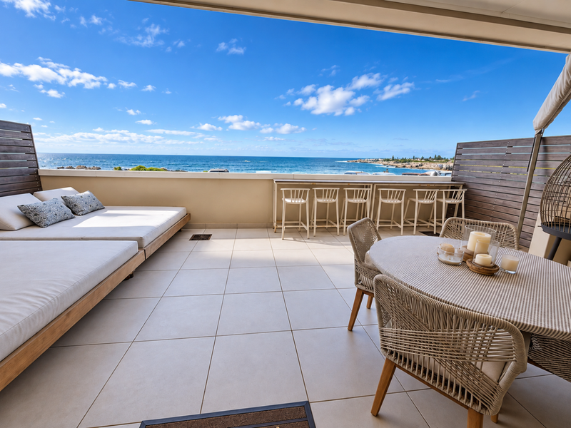 Spacious covered balcony featuring tiled flooring, timber privacy screens, and a built-in bar counter with panoramic ocean views.