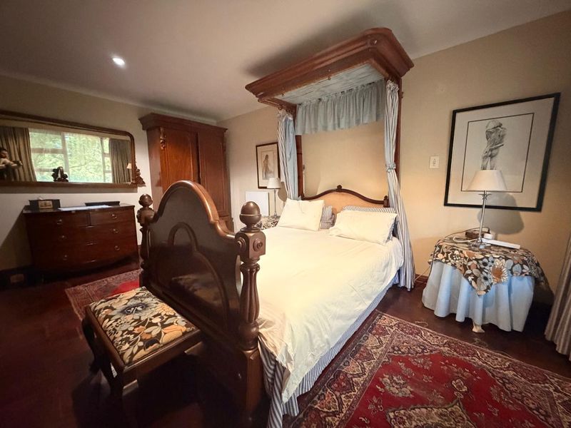 A spacious bedroom featuring warm hardwood flooring and recessed lighting, providing a comfortable and classic living environment.