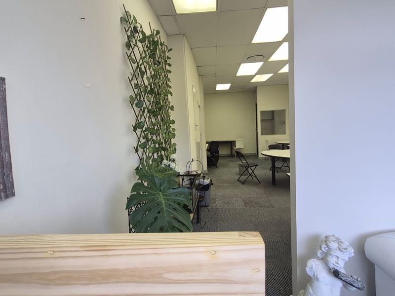 A functional office space featuring a suspended ceiling with recessed lighting and carpeted flooring, suitable for a professional work environment.