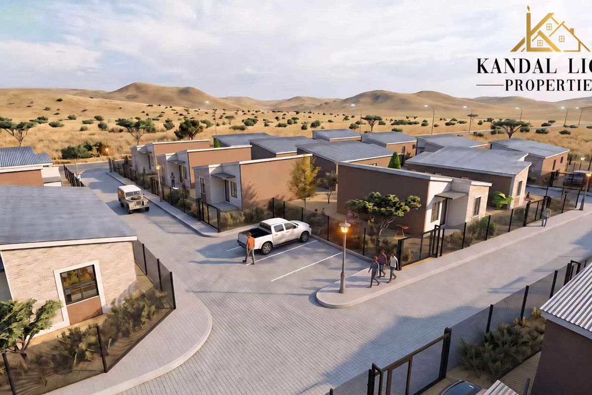 An aerial perspective of a modern townhouse development featuring paved driveways, secure metal fencing, and uniform architectural design within a landscaped estate.