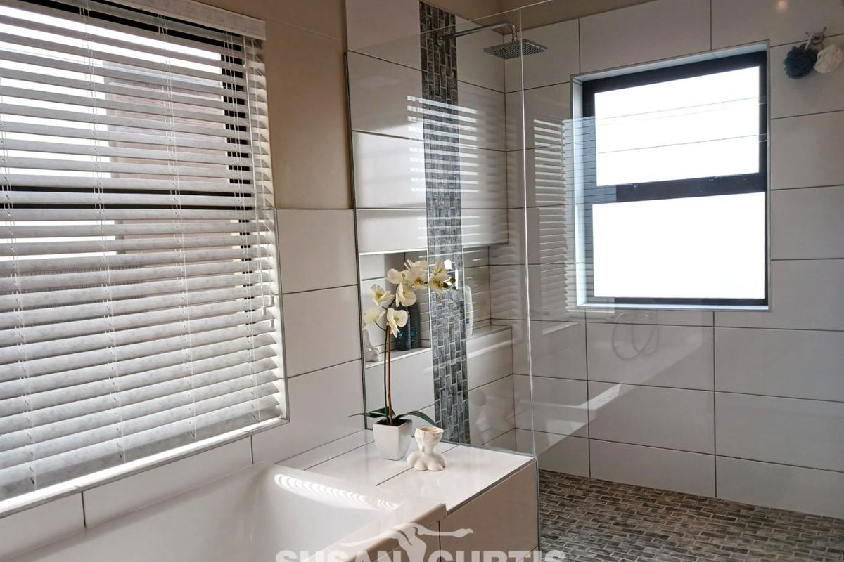 Modern bathroom featuring a built-in bathtub, a glass-enclosed walk-in shower with mosaic tile accents, and large format wall tiles.