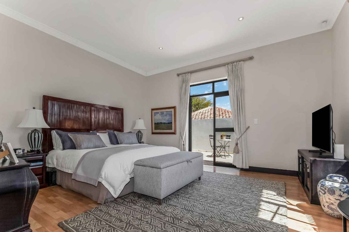 Spacious bedroom featuring hardwood flooring, recessed lighting, and a sliding glass door providing direct access to a private patio area.