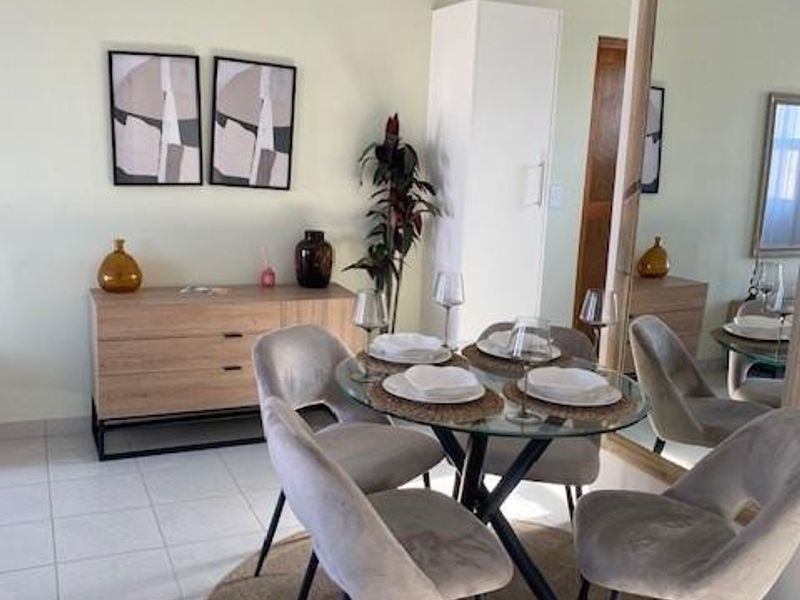 A bright dining area featuring tiled flooring and a vaulted ceiling, providing a comfortable space for meals.