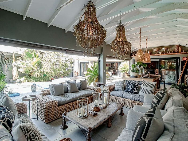 Spacious covered patio featuring exposed timber rafters, tiled flooring, and seamless flow to the outdoor pool area, ideal for relaxed entertaining.