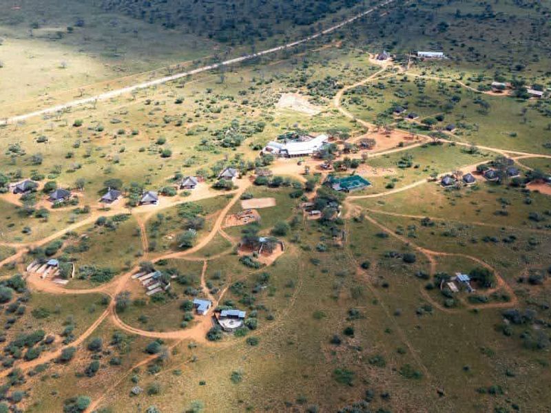 An aerial view of a large, expansive residential land plot featuring multiple scattered structures and an established network of unpaved access tracks.