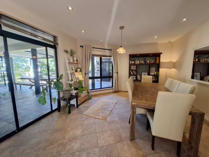Spacious dining area featuring tiled flooring, recessed lighting, and large sliding glass doors that provide seamless access to the outdoor patio.