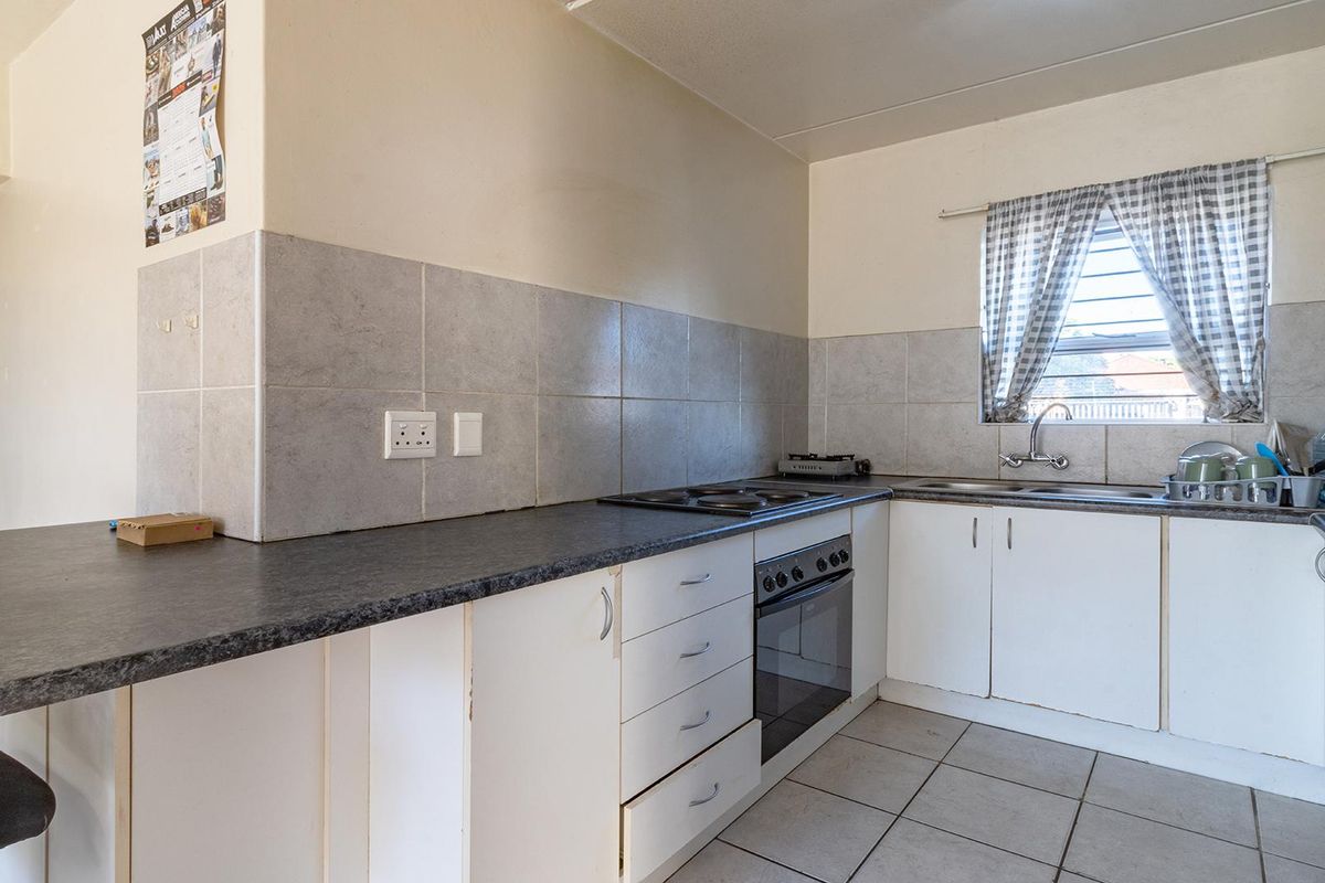 A functional kitchen featuring built-in cabinetry, a tiled backsplash, laminate countertops, and an integrated oven with an electric hob.