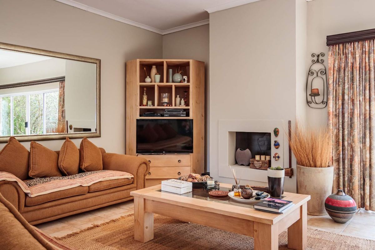 A cozy living room featuring a built-in fireplace, tiled flooring, and neutral wall tones, creating a warm and inviting atmosphere.